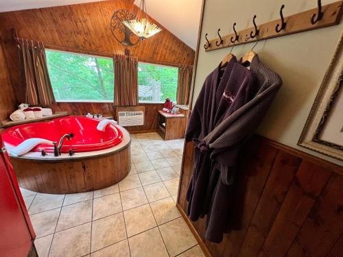 a large bathroom with a red tub and a window at Sherwood Court Cottages in Eureka Springs