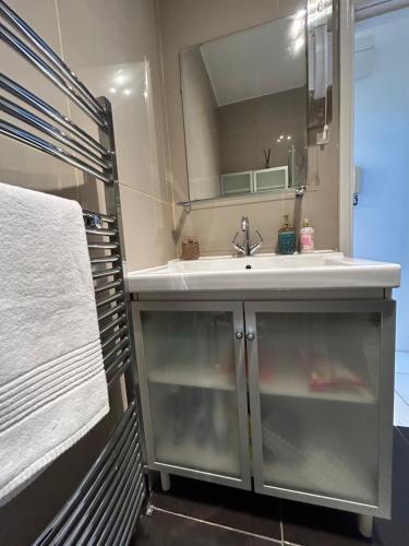 a bathroom with a sink and a mirror at New! Supreme Apartment - Near Tube Stations in London