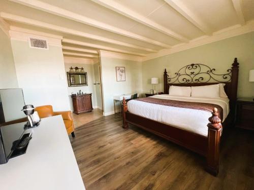 a bedroom with a large bed and a table at Bayfront Inn in St. Augustine