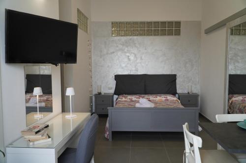 una camera con letto e scrivania con TV di La Sabbia B&B a Bacoli