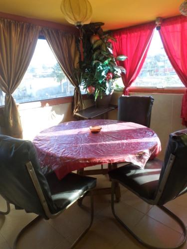 a table and chairs in a room with red curtains at Hospedaje Barato Mi Casita de Colores in Tijuana