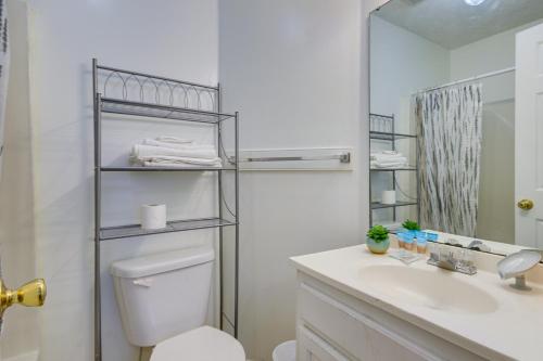 a bathroom with a toilet and a sink and a mirror at Quaint Orangeburg Townhome Near Hospitals and Campus in Orangeburg