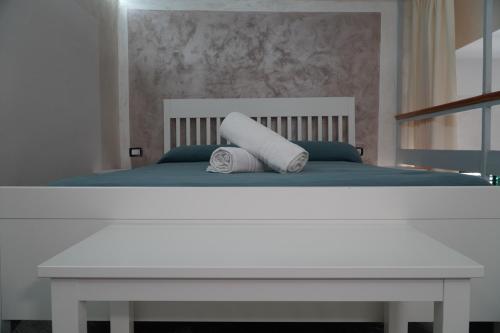 un letto bianco con due cuscini sopra di La Sabbia B&B a Bacoli