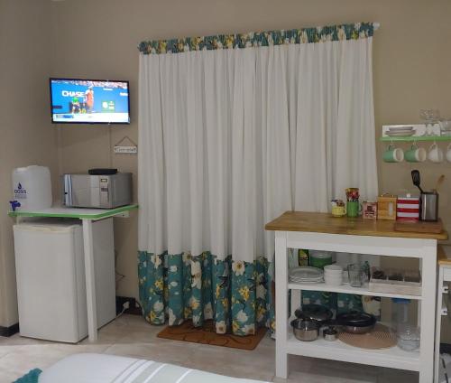 una habitación con una cortina blanca y una mesa en Droom Verlore, en Jeffreys Bay