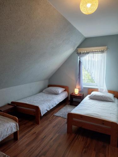 a bedroom with two beds and a window at Verano in Osieki