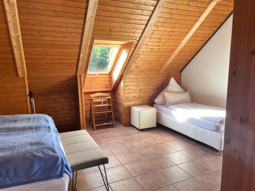 a attic room with two beds and a ladder at Ferienhof am Trift in Bad Saarow