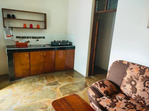 Una sala de estar con un sofá y una cocina. en Sea Breeze Apartments Shanzu Mombasa, en Mombasa