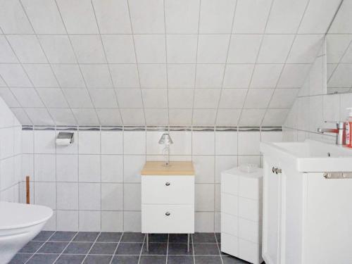 uma casa de banho branca com um lavatório e um WC em Holiday home VISBY III em Visby
