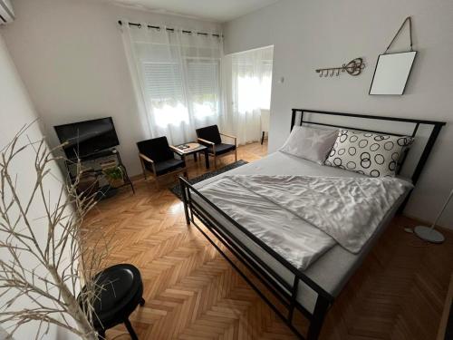 sypialnia z łóżkiem, krzesłami i telewizorem w obiekcie Bubingaa w mieście Kruševac