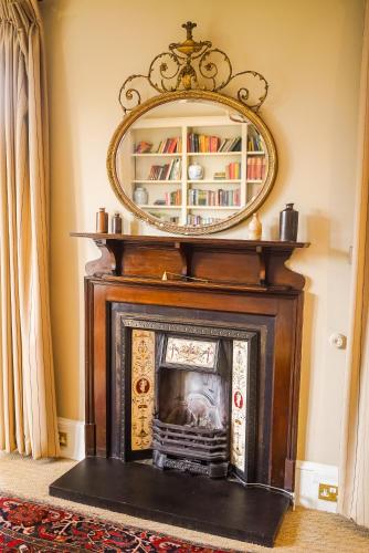 a fireplace with a mirror on top of it at Craigellachie Hotel of Speyside in Craigellachie