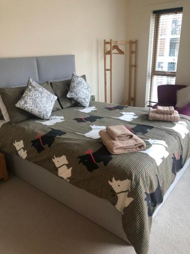 a bed with a comforter with cats on it at Quirky and spacious in Lawley Bank