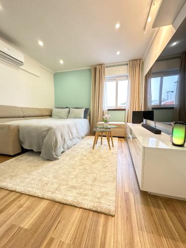 - une chambre avec un lit et un salon dans l'établissement Lisbon Luxury Studio, à Amadora