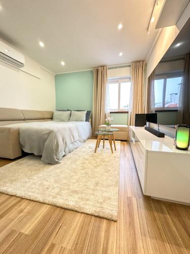 ein Schlafzimmer mit einem Bett und ein Wohnzimmer in der Unterkunft Lisbon Luxury Studio in Amadora