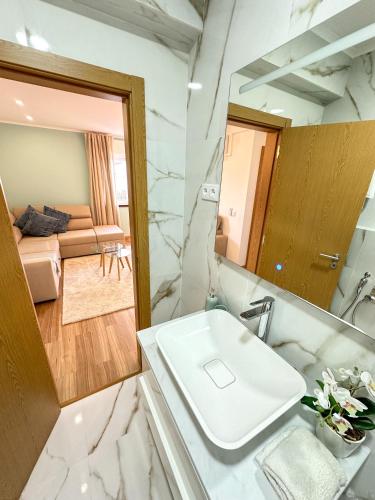 La salle de bains est pourvue d'un lavabo blanc et d'un miroir. dans l'établissement Lisbon Luxury Studio, à Amadora