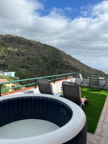 a balcony with chairs and a view of a mountain at Pana House in Calheta