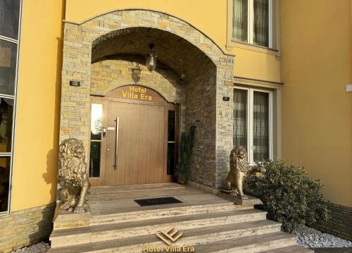 un ingresso a un edificio con statue di leoni davanti a una porta di Hotel ERA a Pristina