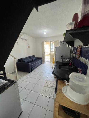 a kitchen and living room with a blue couch at Village Galés de Maragogi in Maragogi