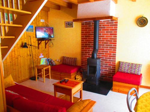 sala de estar con chimenea y muebles de color rojo en Lou cridadé, en Laruns