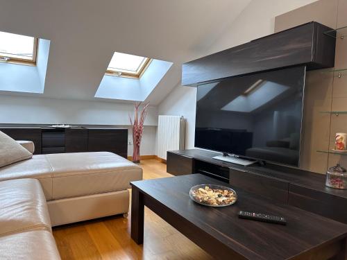a living room with a couch and a large television at Apartamento Gran Vía - PARKING GRATIS in Salamanca