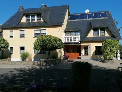 a large yellow house with solar panels on it at Haus Maria in Olmscheid