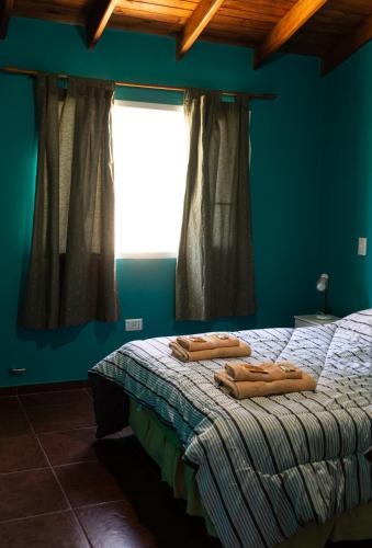 a bedroom with a bed with two towels on it at Casa Yaoyín in El Chalten