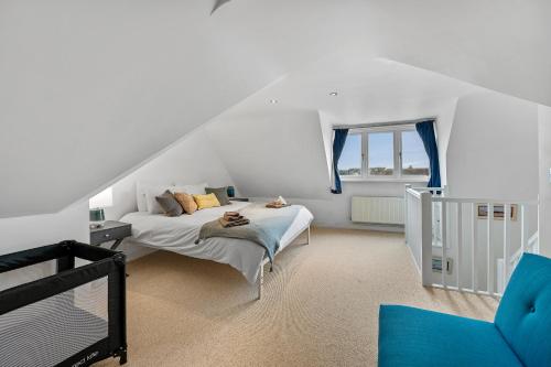 Habitación blanca con cama y ventana en Sea la Vie! Beautifully furnished home in Central Whitstable, en Kent