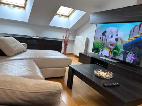 a living room with a couch and a large screen tv at Apartamento Gran Vía - PARKING GRATIS in Salamanca