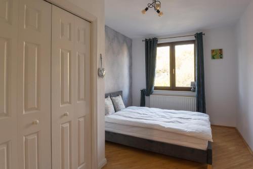 1 dormitorio con cama, ventana y puerta en CASA SPERANTA, en Cugir