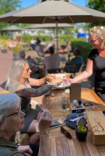 a group of people sitting at a table at Hotel In't Holt 1654 Grand Café & Logement in Zuidhorn