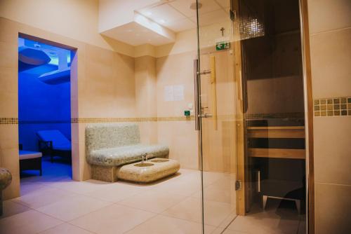 a bathroom with a shower with a bench and a chair at Centrum Misji Afrykańskich - centrum hotelowo-konferencyjne in Borzęcin Duży