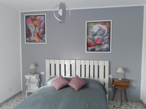 sypialnia z łóżkiem i 2 zdjęciami na ścianie w obiekcie Urban cosy rooms w Rzymie
