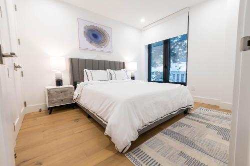 um quarto branco com uma cama grande e uma janela em 149BK-202 NEW Condo 1BR IN PRIME GREENPOINT BK em Brooklyn