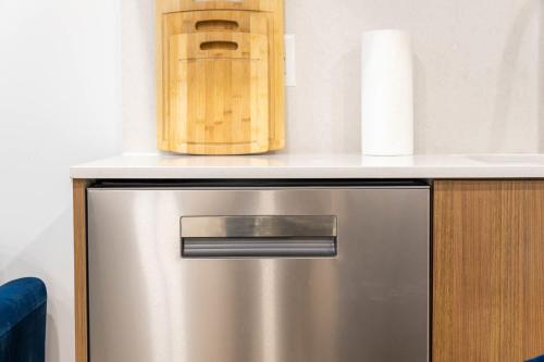 a metal refrigerator with a counter with a box on top at 149BK-202 NEW Condo 1BR IN PRIME GREENPOINT BK in Brooklyn