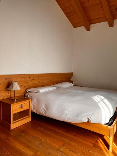 1 dormitorio con 1 cama y 1 mesa con lámpara en Agriturismo Busa dei Sbrase 