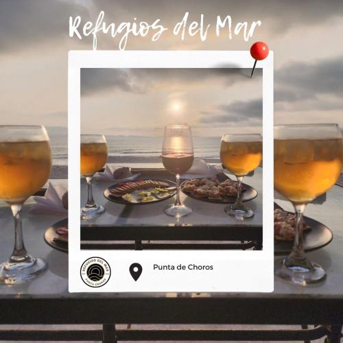 een foto van een tafel met drie glazen wijn bij Refugios del Mar in Punta de Choros