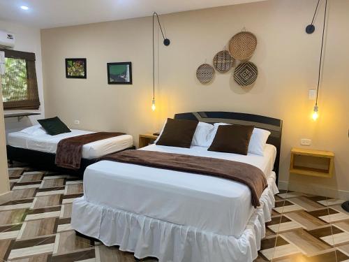 a bedroom with two beds in a room at Hotel La Casablanca Tayrona in Calabazo