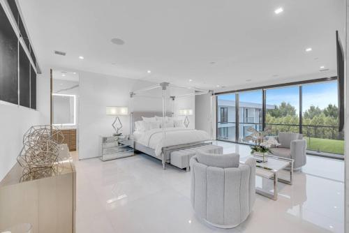 a white bedroom with a bed and a living room at Exquisite Hamptons Mansion Retreat in Water Mill
