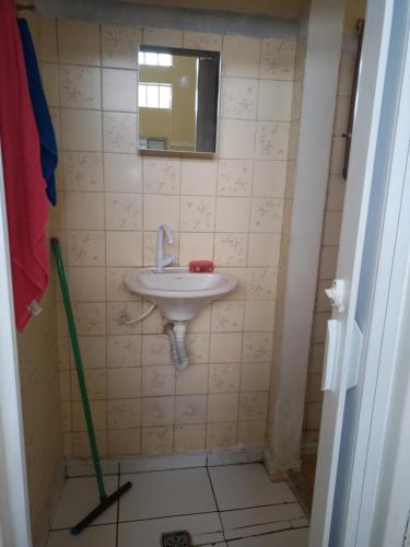 a bathroom with a sink and a mop at Casa de hospedagem in Aparecida