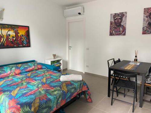 ein Schlafzimmer mit einem Bett, einem Schreibtisch und einem Tisch in der Unterkunft Villa Popilia Sea&Business Blue in Rimini