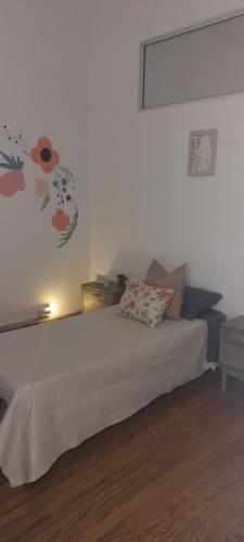 ein Schlafzimmer mit einem Bett mit Blumen an der Wand in der Unterkunft La Casa de las Flores in Salta