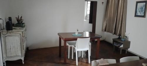 uma mesa de jantar com cadeiras brancas e uma mesa de madeira em La Casa de las Flores em Salta