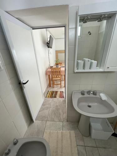 a bathroom with a sink and a toilet and a mirror at El Catorce Departamento Temporario in Formosa