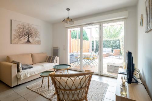 un salon avec un canapé et une table dans l'établissement Appartement Exupéry - Welkeys, à La Teste-de-Buch