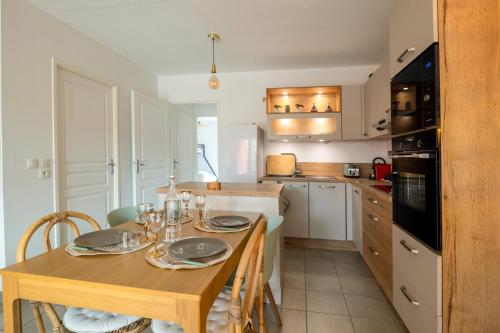 une cuisine avec une table en bois et des plaques de cuisson. dans l'établissement Appartement Exupéry - Welkeys, à La Teste-de-Buch