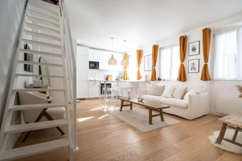 een witte woonkamer met een witte bank en een tafel bij Beautiful duplex on the outskirts of Paris - Welkeys in Levallois-Perret