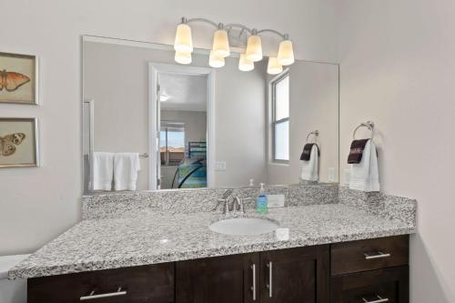 ein Badezimmer mit Waschbecken und großem Spiegel in der Unterkunft Paradise Village 107 Private Pool, Hot Tub, Pickle-ball, Basketball, Futsal Court, and Game Room in Santa Clara