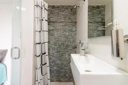 Baño blanco con lavabo y espejo en Habitación equipada, baño independiente y cocina. Cerca del Centro Histórico, en Ciudad de México