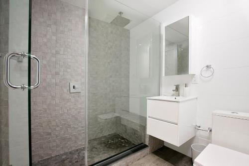 baño blanco con ducha y lavamanos en 24-6 Gramercy area Newly reno Studio W D in unit, en Nueva York