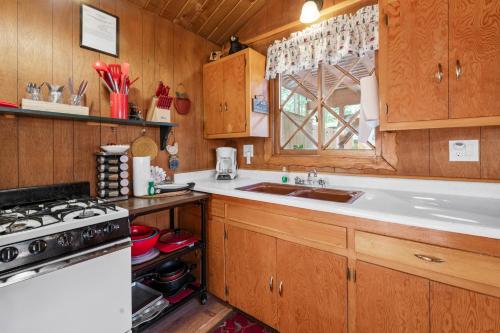 a kitchen with wooden cabinets and a sink and a stove at Sugar Pine - Quiet neighborhood, nice to grill and eat outside! Fenced backyard with a new deck! in Sugarloaf