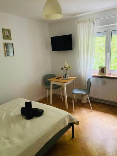 a bedroom with a table and a bed and a desk at Ferienwohnung „Marina“ im Schwarzwald in Lörrach